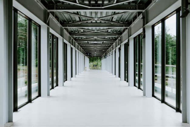 white-hallway-with-glass-doors-metal-ceiling-modern-building_181624-7177